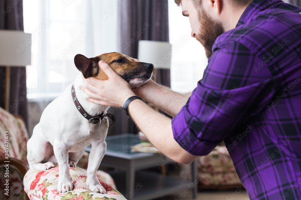 Φωτογραφία Close Up portrait handsome young hipster man plays and loves his good friend dog at home