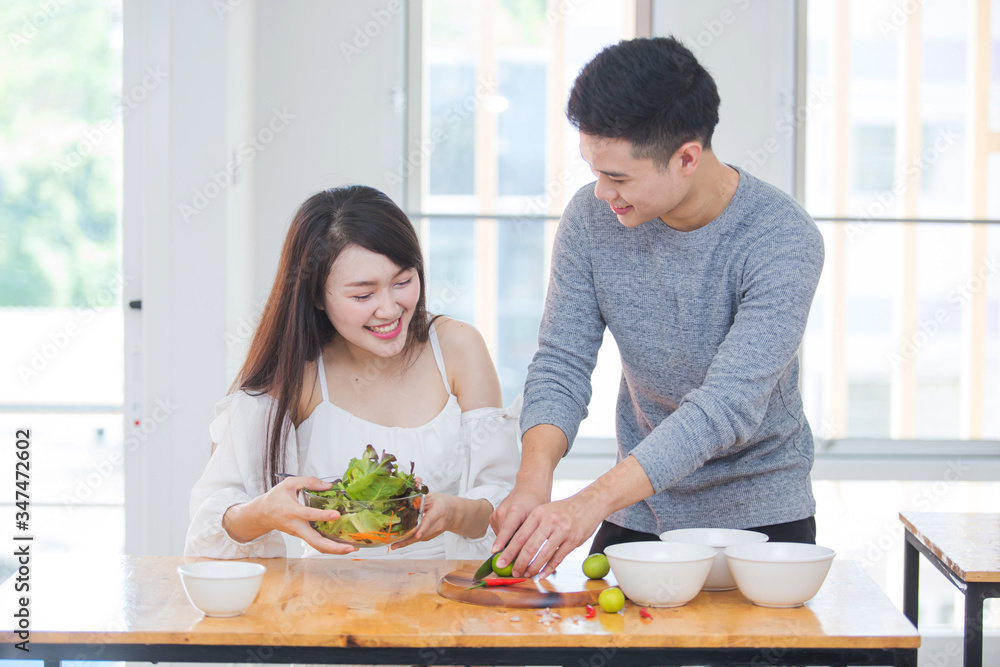 Asian couples making salads and eating cleanfood , healthy meals. Stay at home happily Asian couples making salads and eating cleanfood , healthy meals. Stay at home happily