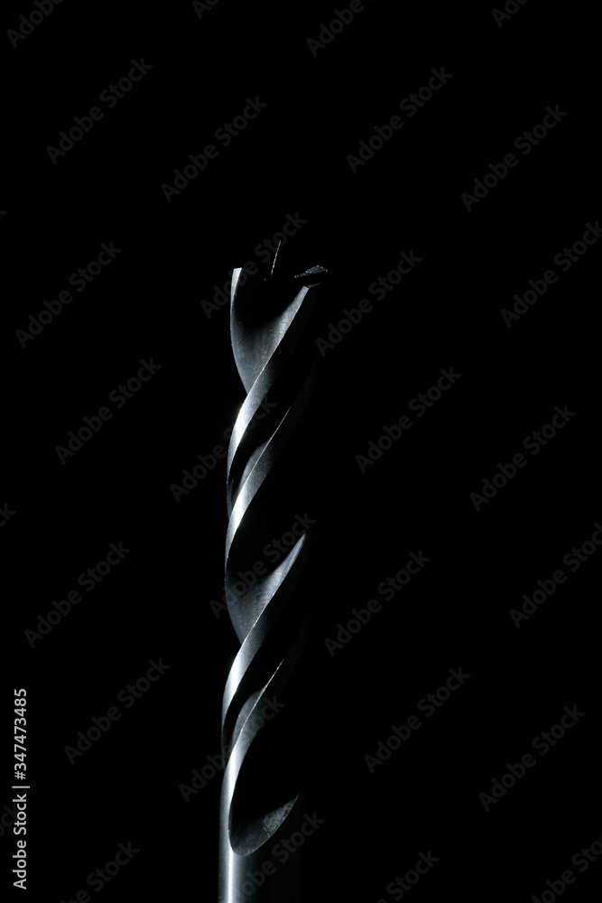 Wood spiral drill bit with black background and vertical framing Wood spiral drill bit with black background and vertical framing