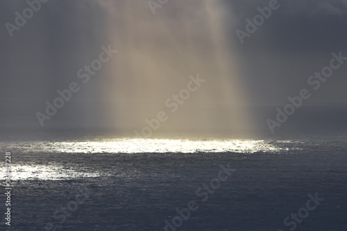 Rays of light that pass over the clouds and illuminate the sea like spotlights. Concept of nature and sea. Galicia, Spain