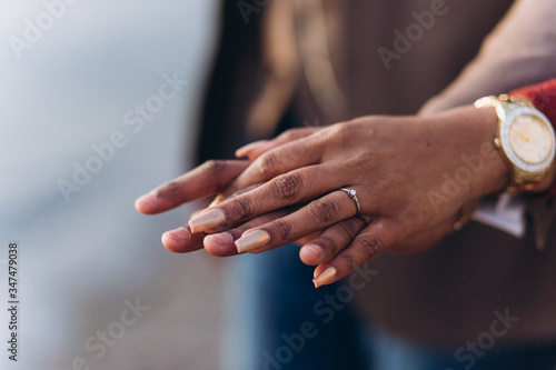 Hands of couple with engagement ring, hold each other together