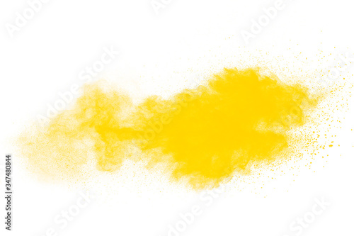 Yellow dust particles explosion on white background.Yellow powder dust splash.