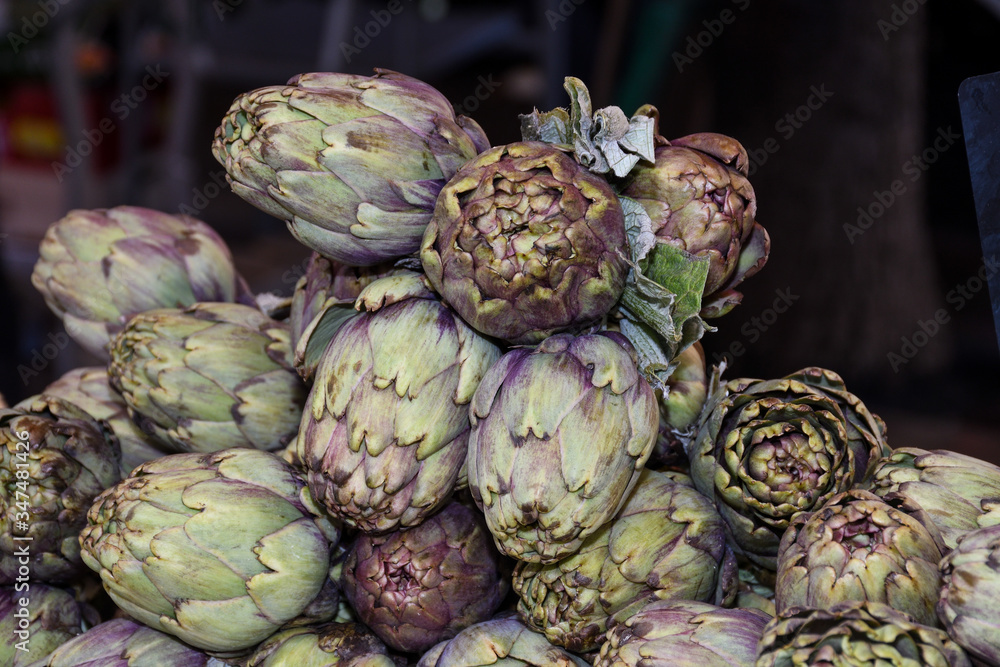 Fototapeta premium Fresh artichokes at farmers market. Local produce stack or pile for sale at the farmers market