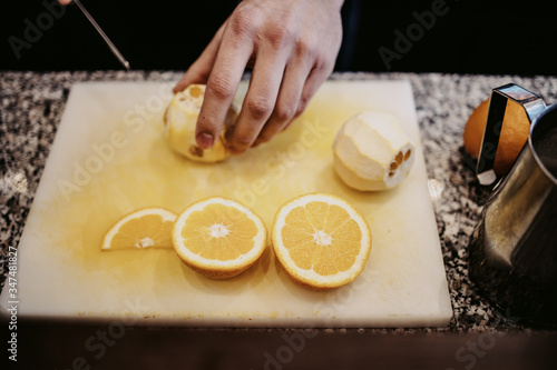 Professional bartender cutting orange and preparing fresh orange juice