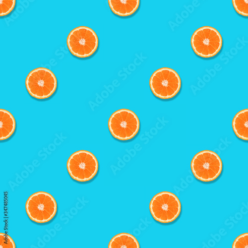 Pattern of orange slices on a blue background. Seamless texture. Top view, flat lay.