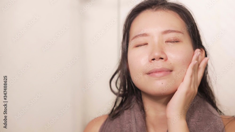 young happy and beautiful Asian Korean woman applying moisturizer facial cream and beauty treatment at home bathroom in morning routine smiling cheerful and fresh young happy and beautiful Asian Korean woman applying moisturizer facial cream and beauty treatment at home bathroom in morning routine smiling cheerful and fresh