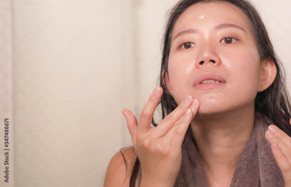 young happy and beautiful Asian Korean woman applying moisturizer facial cream and beauty treatment at home bathroom in morning routine smiling cheerful and fresh young happy and beautiful Asian Korean woman applying moisturizer facial cream and beauty treatment at home bathroom in morning routine smiling cheerful and fresh