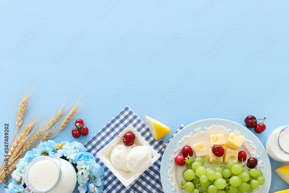 Top view photo of dairy products over pastel blue background. Symbols of jewish holiday - Shavuot - obrazy, fototapety, plakaty 