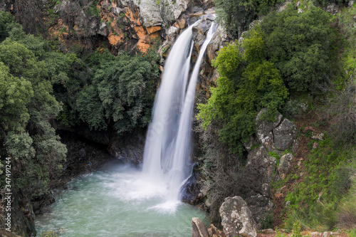 High waterfall and greenery all around. Long exposure photography.