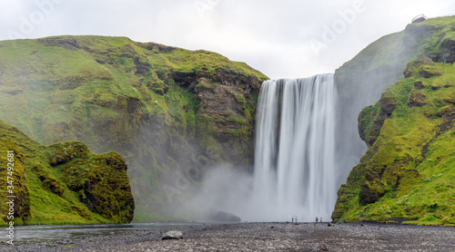 Tourists and couple infront of Skogarfoss waterfall in Iceland. Travelers and holiday concept.