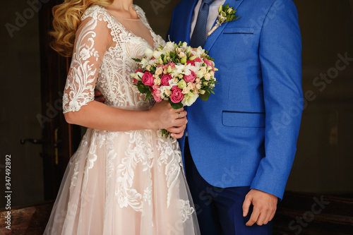 Bride and groom holding colorful wedding bouquet at wedding day