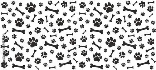Seamless endless pattern of traces of dog paws. Dog legs and bones. Monochrome black and white. 