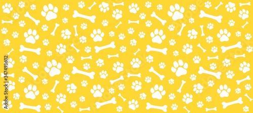 Seamless endless pattern of traces of dog paws. Dog legs and bones. Monochrome yellow print