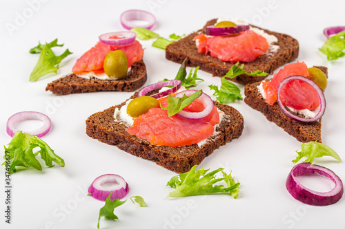 Appetizer, open sandwich with salmon and onion on white background. Traditional Italian or Scandinavian cuisine. Concept of proper nutrition and healthy eating. Close up, copy space for text