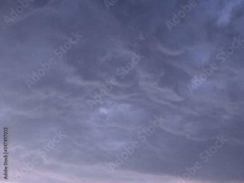 Blue background with heavy thunder clouds in the sky, space for text