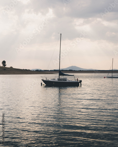 Sailboat anchored in a lake surrounded by mountains © Iván Berrocal