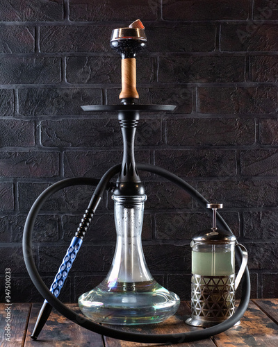 black hookah with green tea on black brick wall background