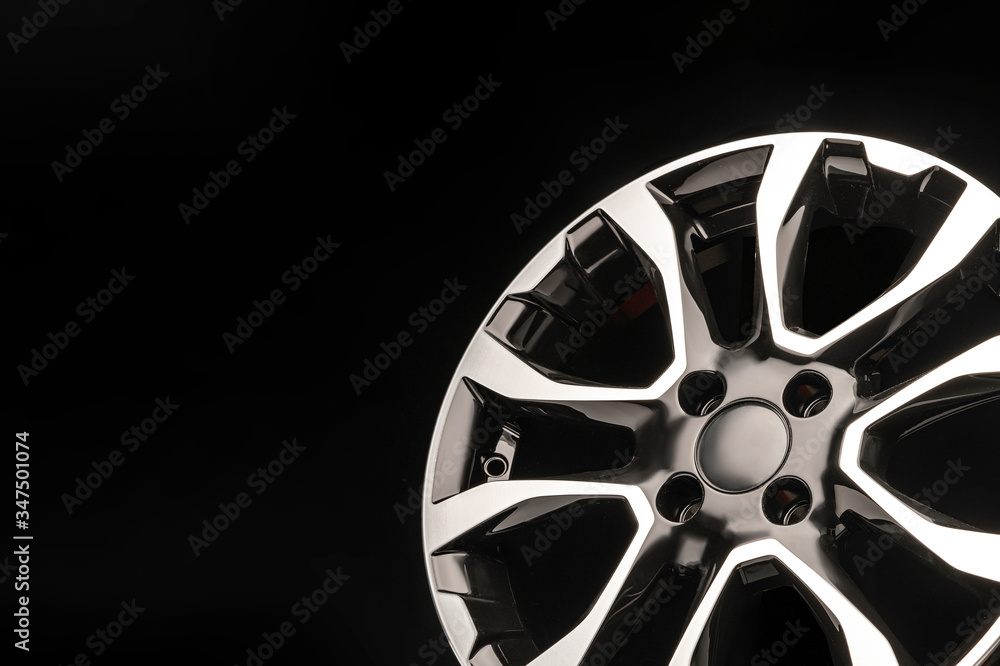 Obraz premium stylish alloy wheels, black with silver and polished on a dark background. copyspace