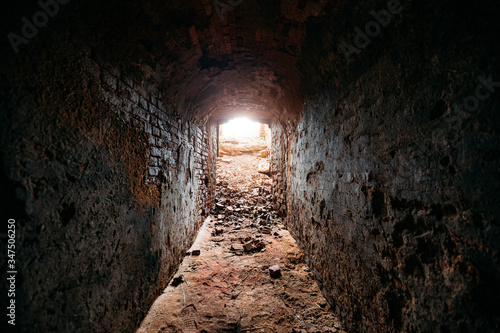 Historical underground red brick passage. Light at the end of tunnel © Mulderphoto