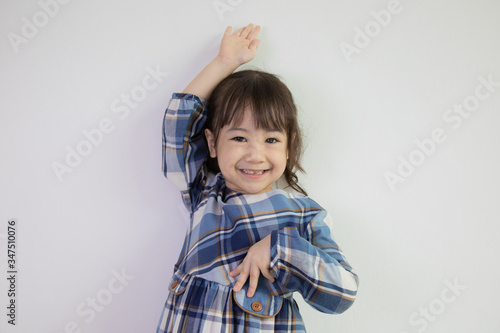 half-body and front-view photo of adorable, three-year-old Asian girl posing on a white background shows her brightness that makes people look happy, bright and cute.