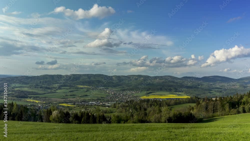 Timelapse of moving clouds over a village that lies in a mountainous area surrounded by hills White clouds move rapidly in sky shadows change land full of nature and fields around village of Zasova Timelapse of moving clouds over a village that lies in a mountainous area surrounded by hills White clouds move rapidly in sky shadows change land full of nature and fields around village of Zasova