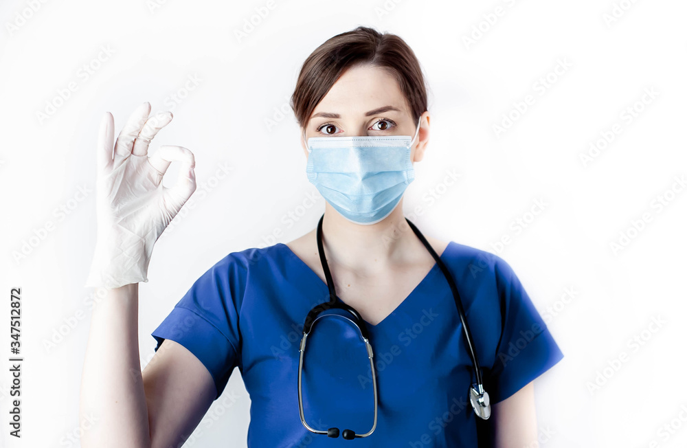 Doctor girl in a medical mask shows with a hand gesture that everything is fine on a white background with copy space for your text Doctor girl in a medical mask shows with a hand gesture that everything is fine on a white background with copy space for your text