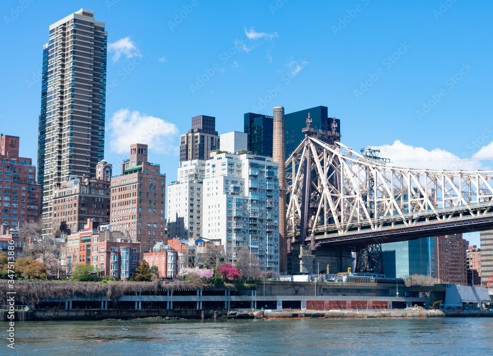 Skyline of Midtown Manhattan during Spring with the Queensboro Bridge along the East River in New York City Skyline of Midtown Manhattan during Spring with the Queensboro Bridge along the East River in New York City