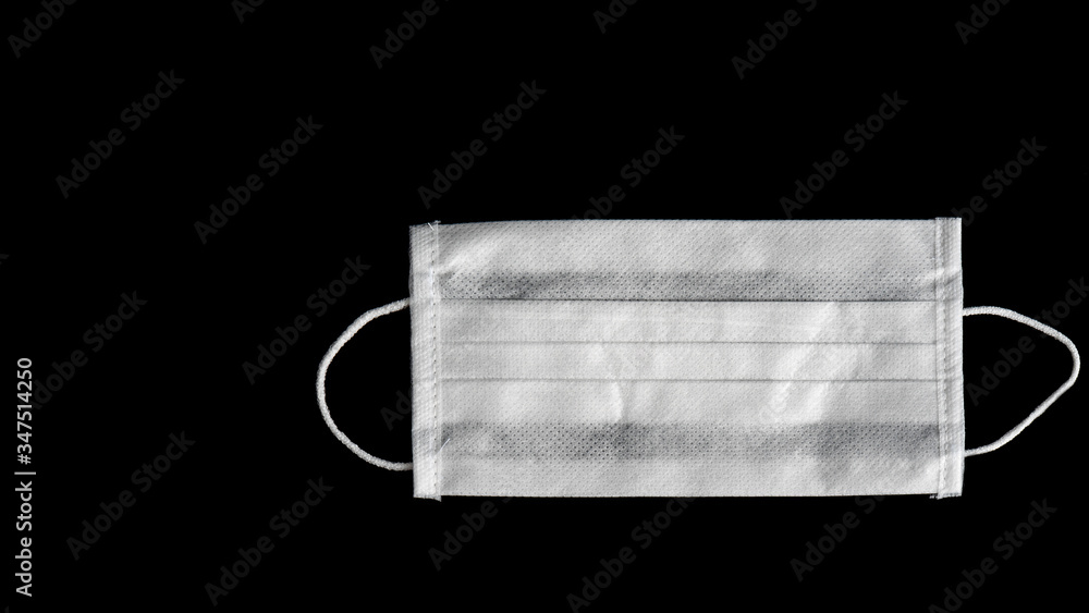 Close-up shot of medical mask isolated on black background. Copy space for text message. Close-up shot of medical mask isolated on black background. Copy space for text message.