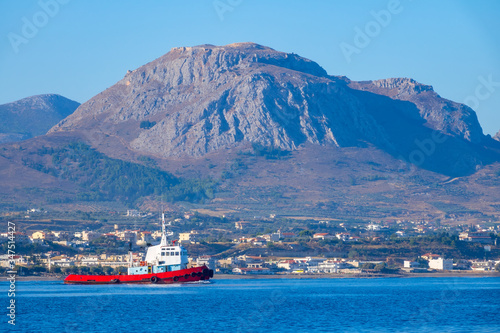 Tugboat on a Background of a Sunny Mountainous Coast