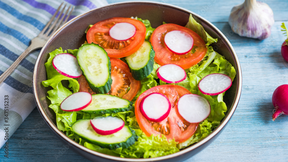 A very simple salad with fresh cucumbers, radishes, tomatoes and lettuce - homemade summer salad A very simple salad with fresh cucumbers, radishes, tomatoes and lettuce - homemade summer salad