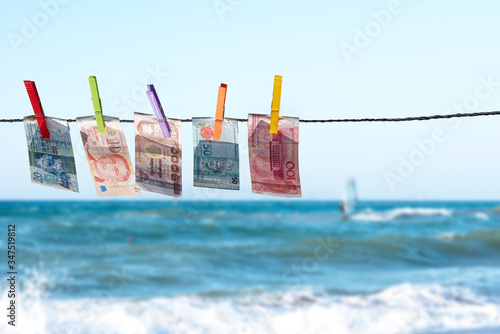 Photography Money of south-east Asia with a clothespin on a rope opposite the sea