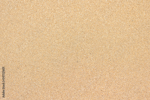 Seamless wet yellow sand background on sunset beach. Close-up
