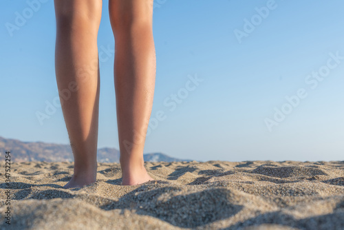 Woman walking on sand beach on a sunset. Travel, relaxation, positive emotions. Concept