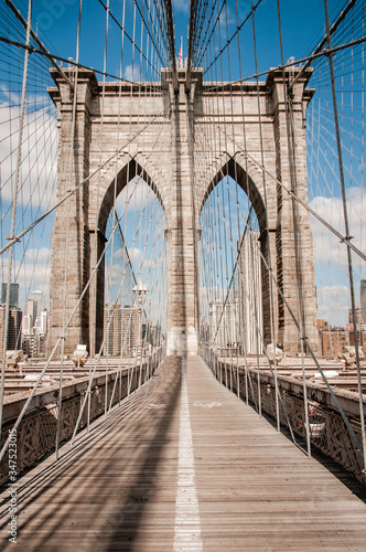 brooklin bridge arch on a sunny day with blue sky and clouds © Juan