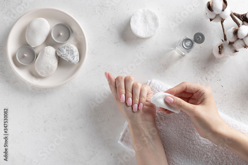 Tableau sur toile young woman removing pink nail polish with remover liquid