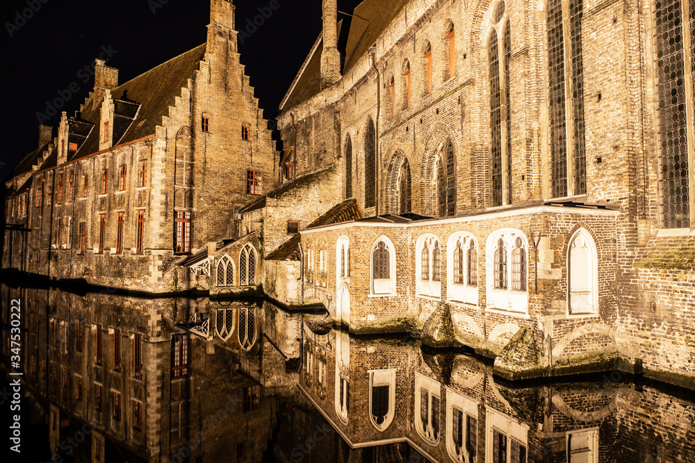 Fototapeta premium Light night with buildings with reflections around channels in Bruges