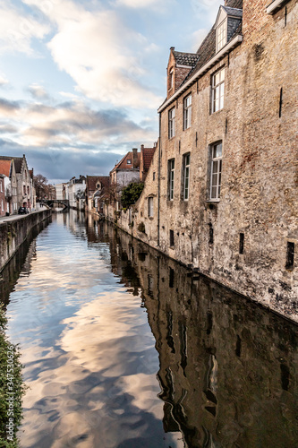 Buildings around channels in Bruges at sunset