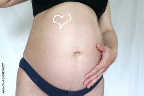 Wallpaper Mural heart painted with cream on a pregnant woman’s tummy Torontodigital.ca