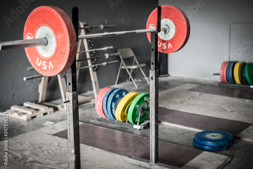 Fotografie Weight plates on a barbell over an olympic platform.