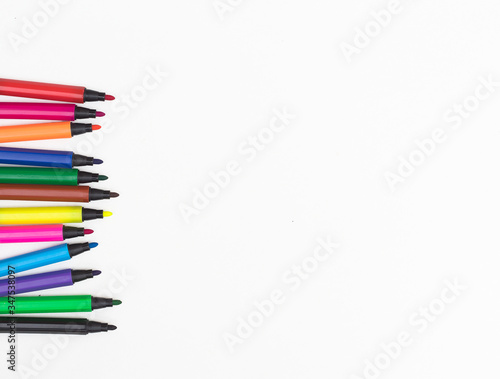 Colorful marker pen set messily placed on white background.