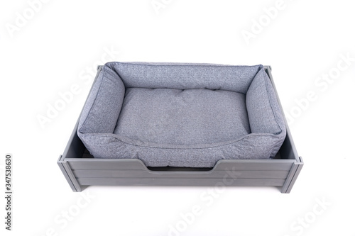 Sofa for a animals in blue on a wooden stand with legs on a white background. Isolate