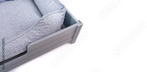 Corner of the bed for dogs and cats with a wooden base on legs on a white background. Place for text.