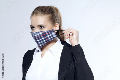 Trendy commuter girl removes homemade face mask and isolates herself against white background during new coronavirus pneumonia outbreak