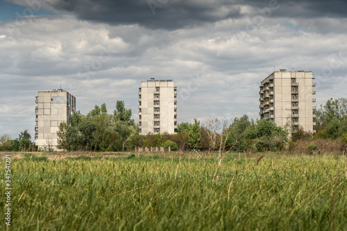 Old Soviet socialist prefabricated apartment buildings in the summer afternoon in the field. © Dmytro