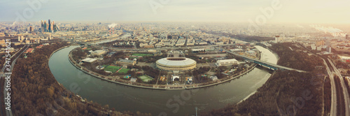 Aerial view of stadium and Moskva river. Moscow-city towers on the horizon. Beautiful spring sunrise over the city.