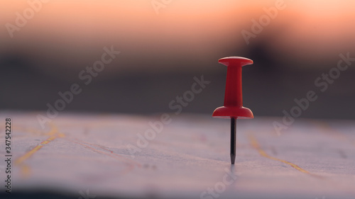 Canvas Print Close up red pin push map under sunset background