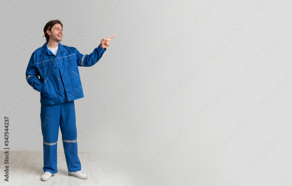Civil Engineer In Work Uniform Pointing Aside At Copy Space Civil Engineer In Work Uniform Pointing Aside At Copy Space