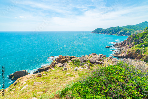 Expansive view of scenic tropical bay, lush green woodland and blue waving sea. The easternmost coast in Vietnam, Phu Yen province between Da Nang and Nha Trang.