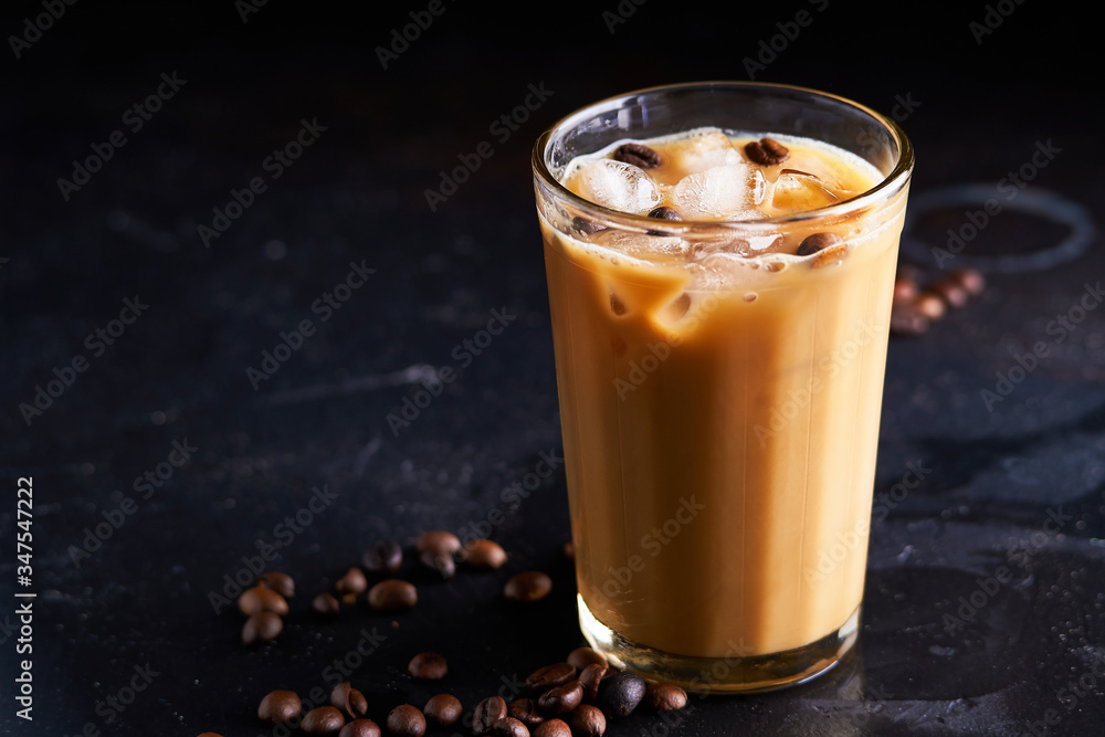 Tasty ice coffee with milk , cold drink in glass on dark background Tasty ice coffee with milk , cold drink in glass on dark background