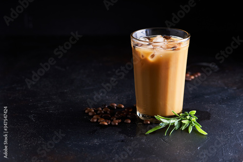 Tasty ice coffee with milk , cold drink in glass on dark background